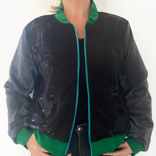 Person wearing a black jacket with green accents on a white background