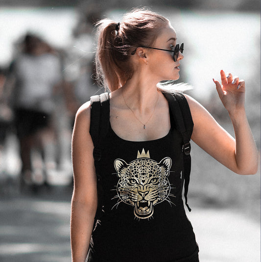 A woman wearing sunglasses and a black tank top with a gold foil print of a leopard queen.