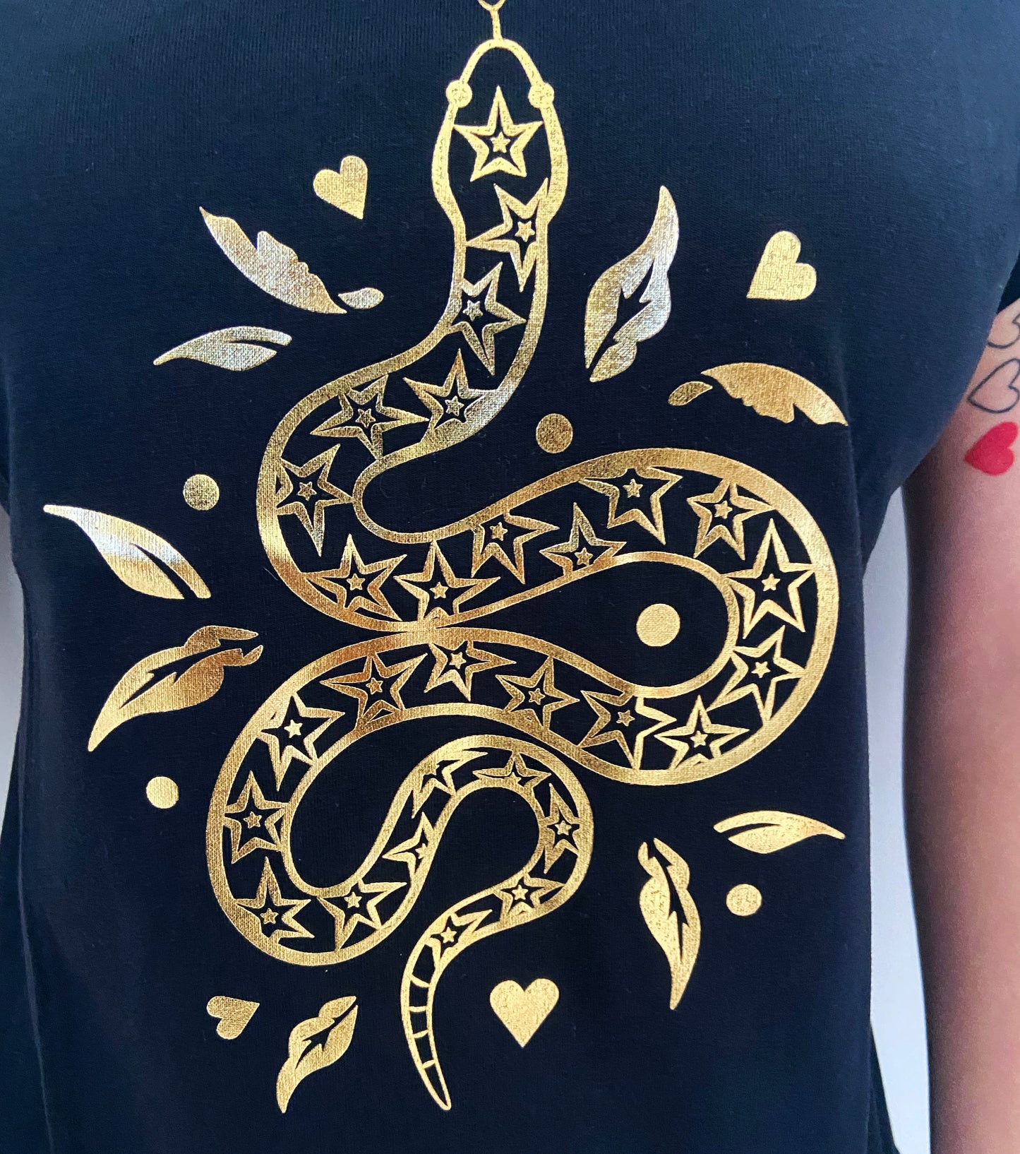 Black t-shirt with a gold snake design on a plain background