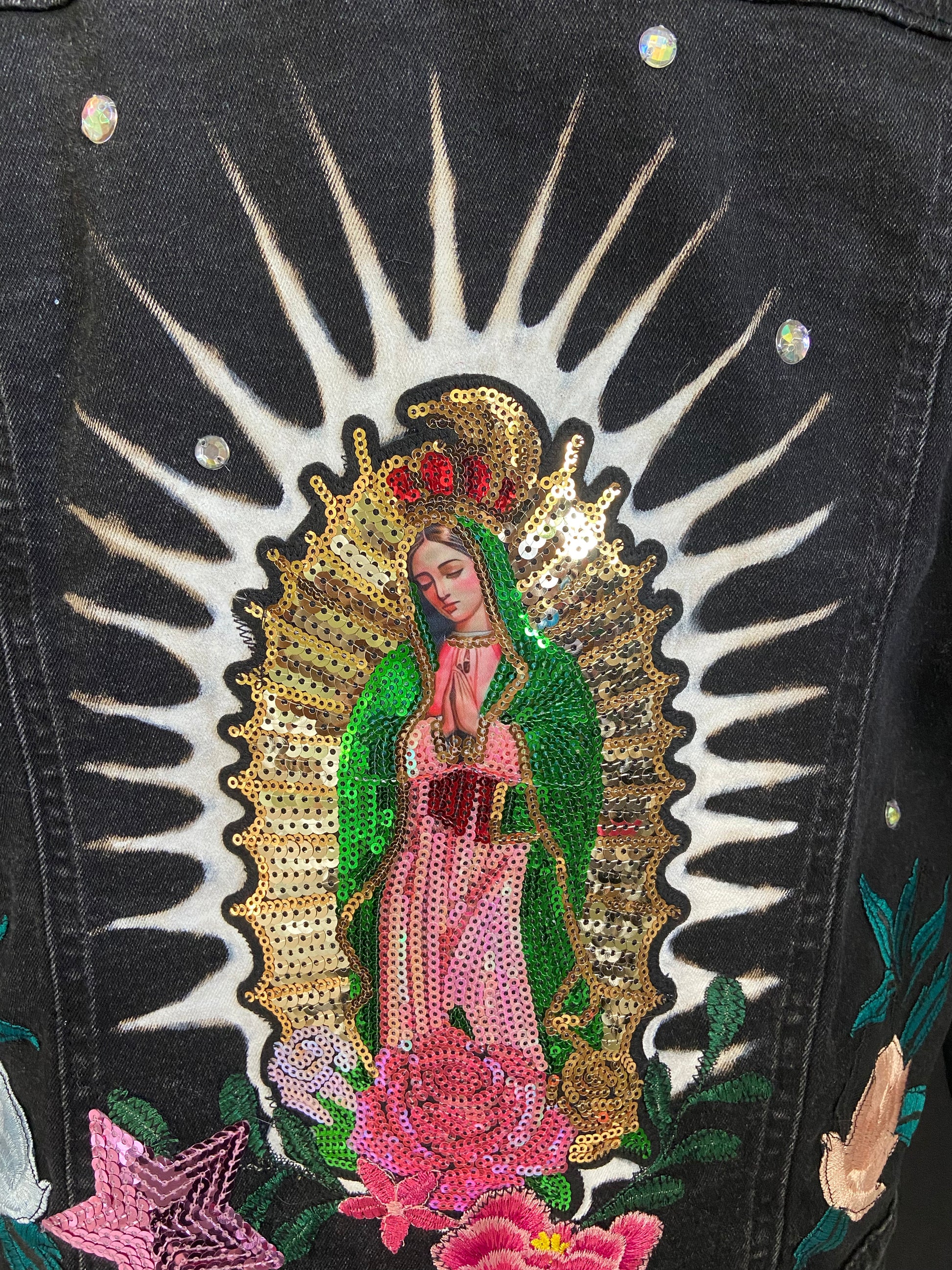 Embroidered design of a religious figure on a black background