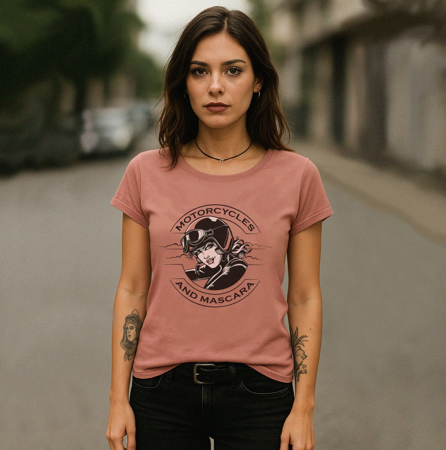 Woman wearing a pink t-shirt with a graphic design on a street.