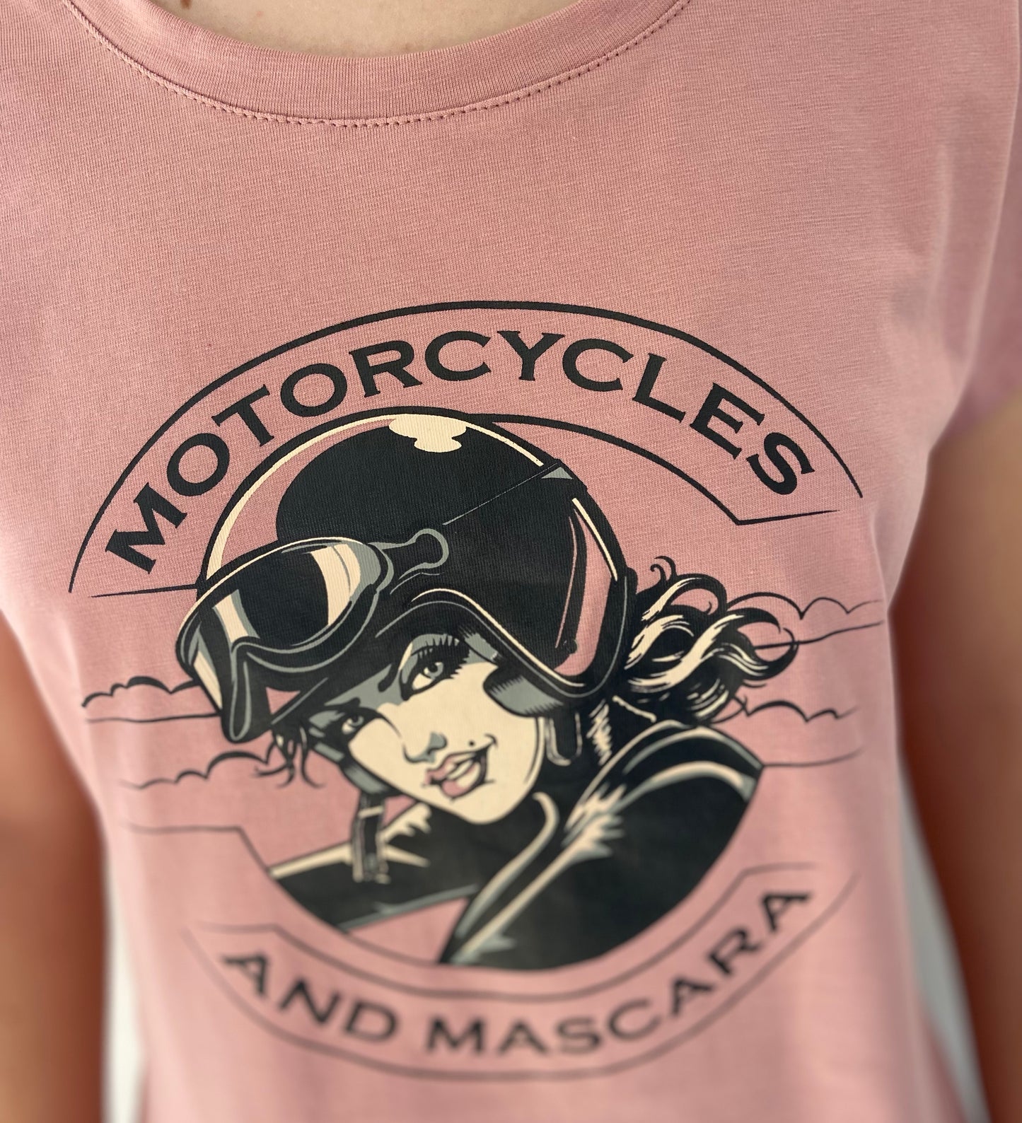 Pink t-shirt with a graphic of a woman wearing goggles and a helmet, with 'Motorcycles and Mascara' text.