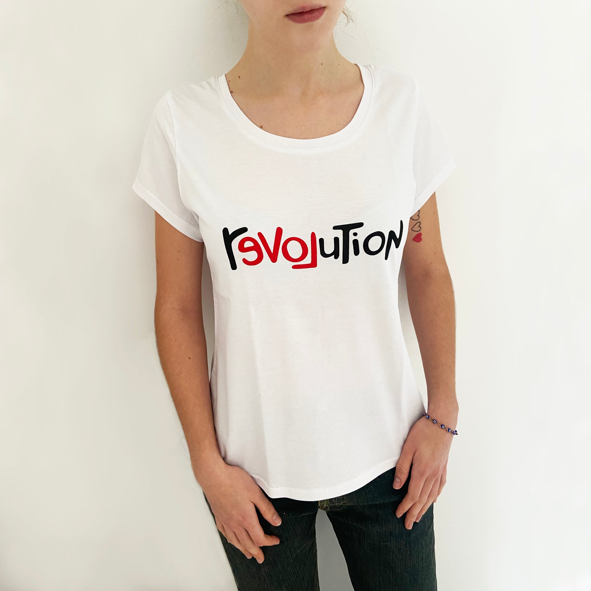 Person wearing a white t-shirt with 'Revolution' printed on it against a plain background