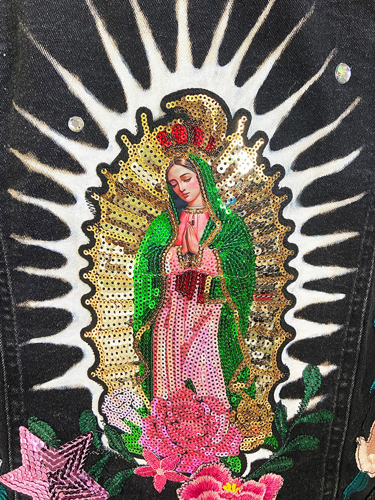 Embroidered patch of a religious figure with sequins on a black background