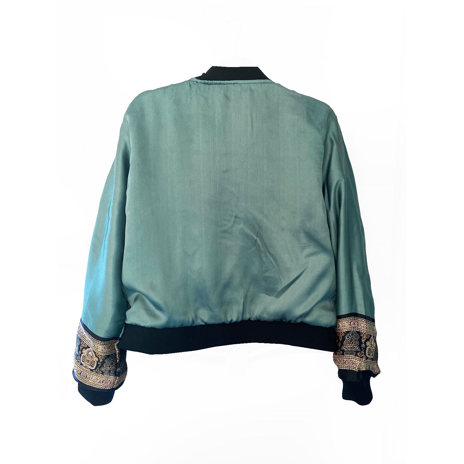 Teal bomber jacket with patterned cuffs on a white background