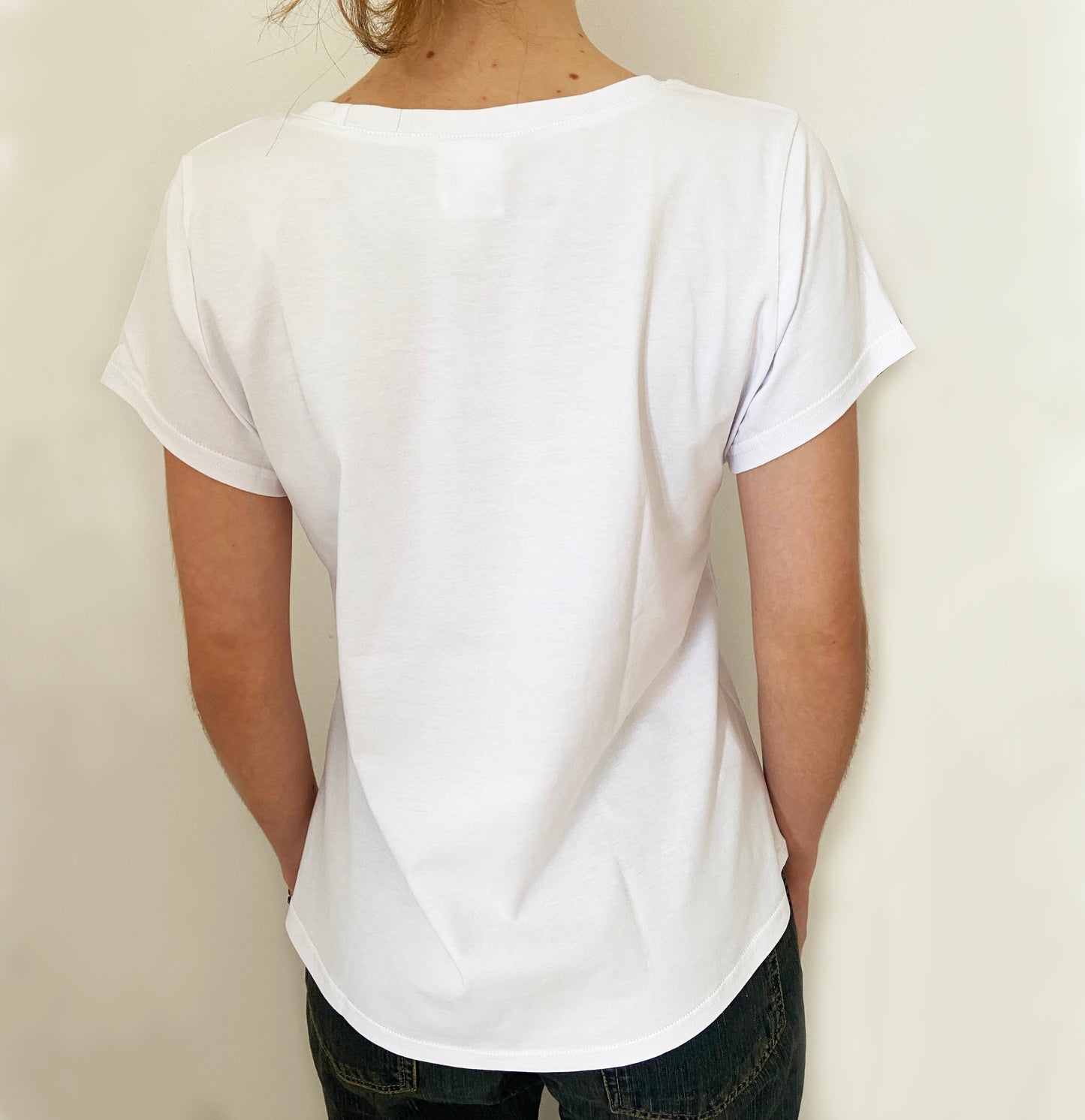 Person wearing a plain white t-shirt against a light background