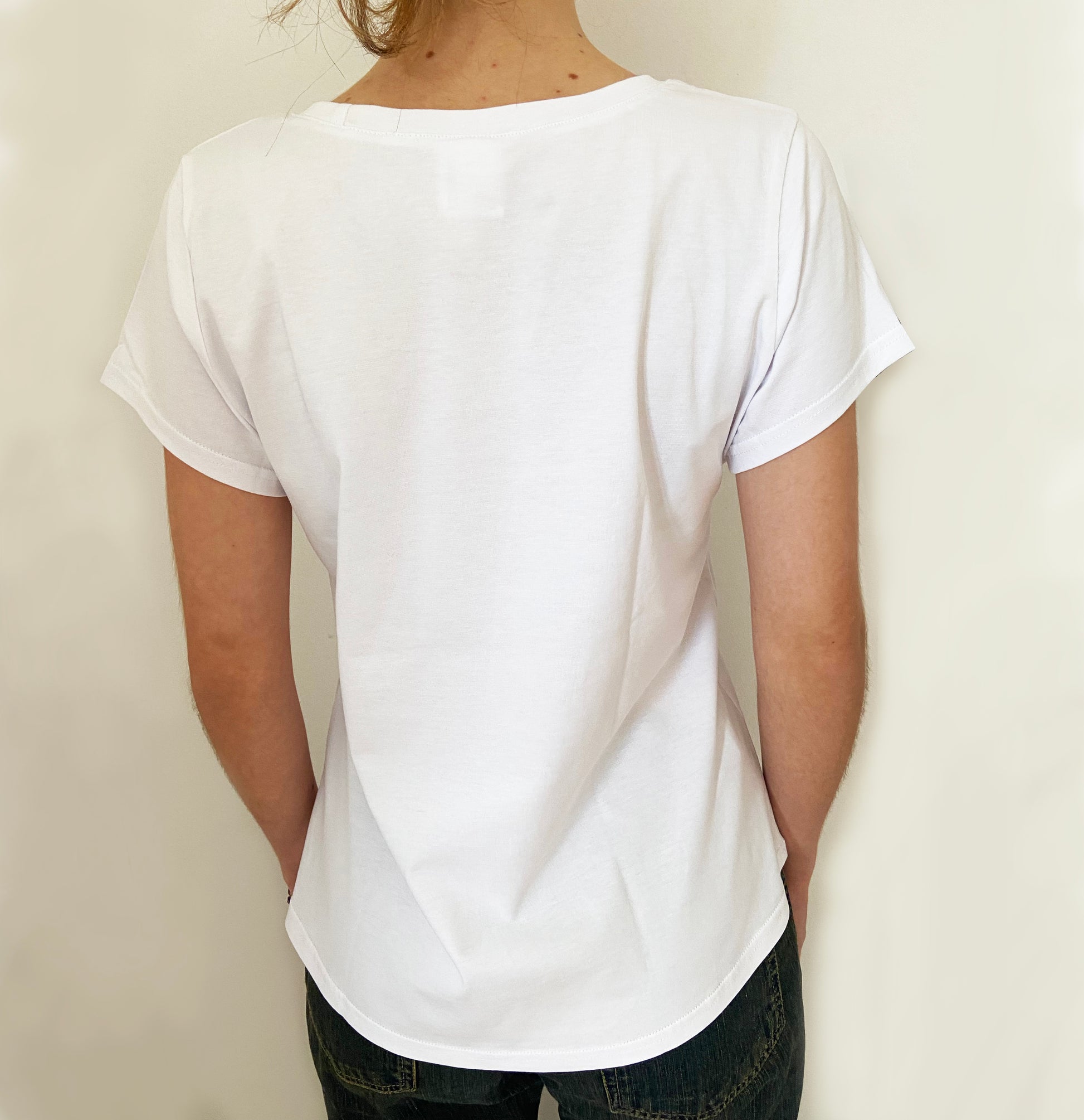 Person wearing a plain white t-shirt against a light background
