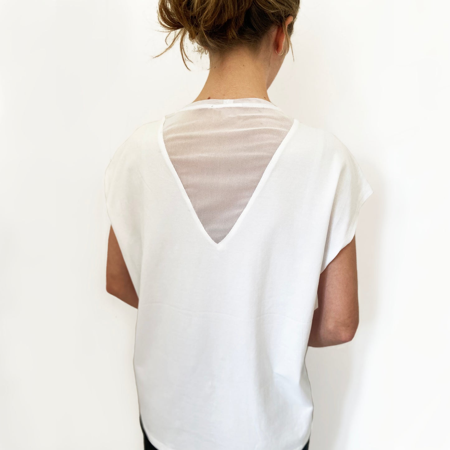 White blouse with sheer sleeves and back design on a plain background