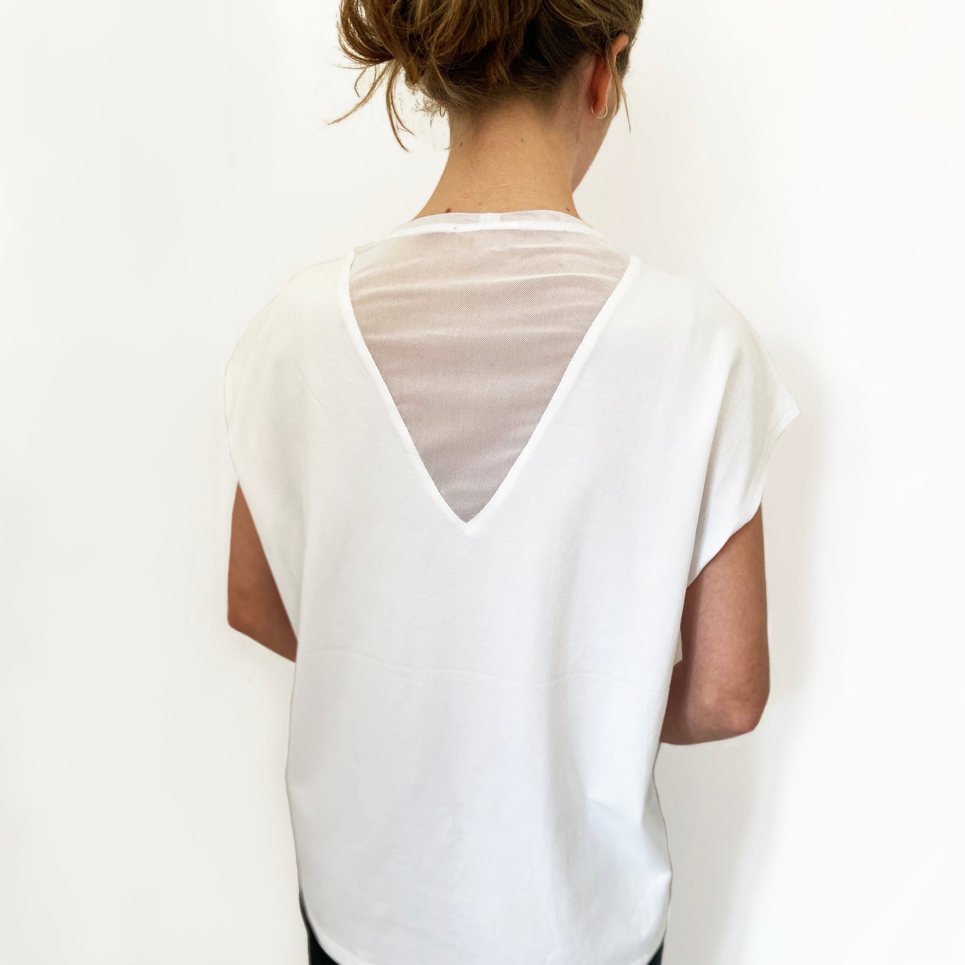 White blouse with sheer sleeves and back design on a plain background