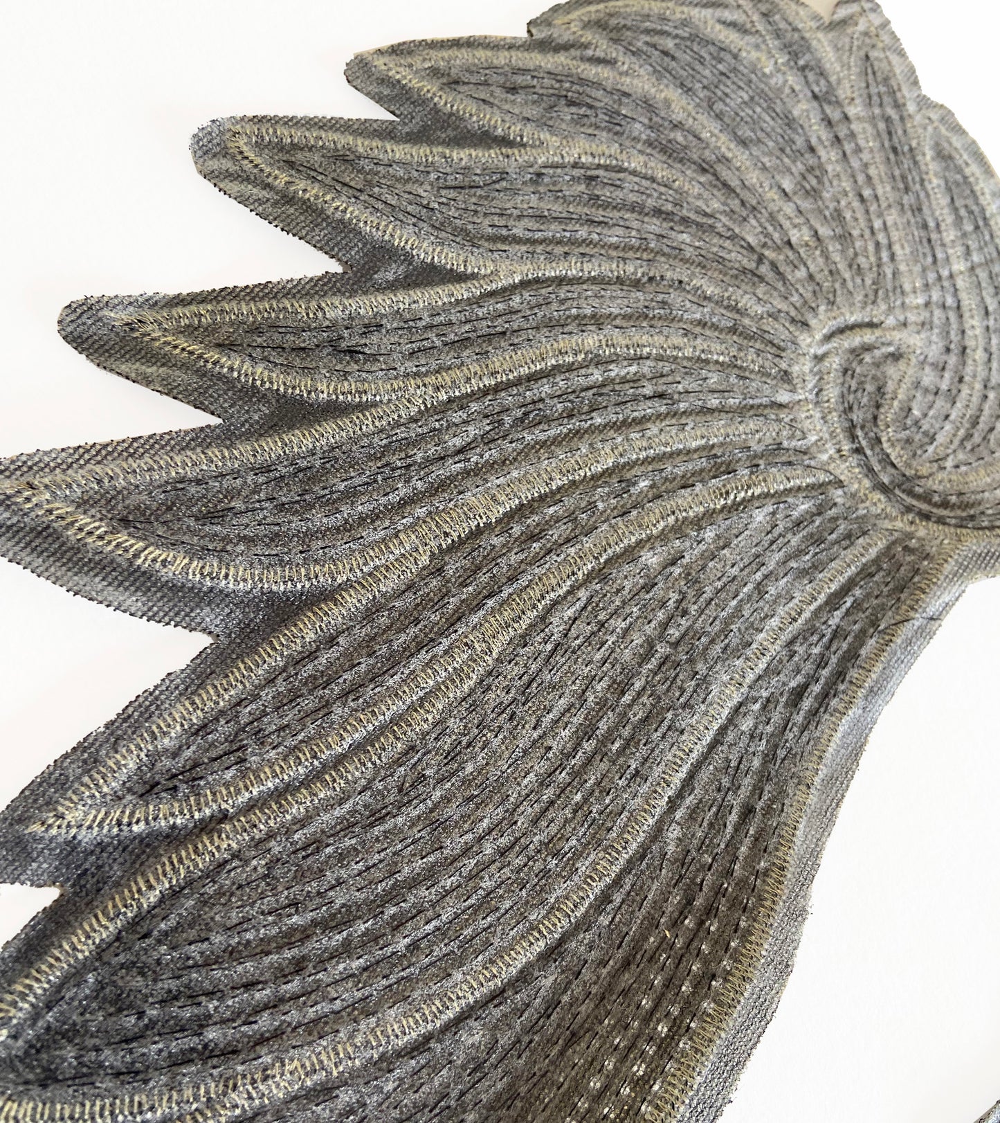 Close-up of a decorative metallic leaf design on a white background