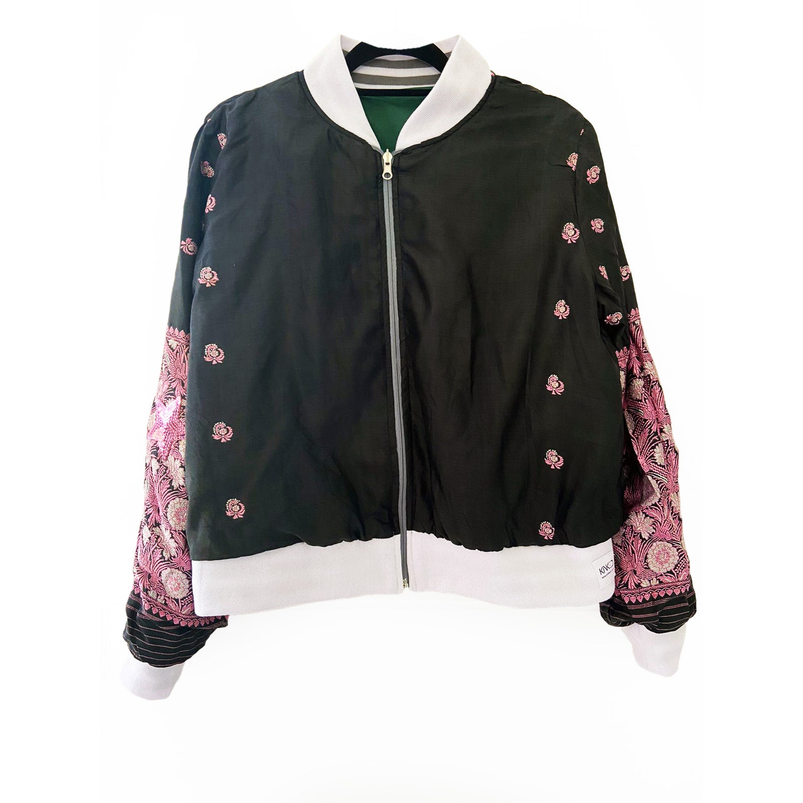 Black bomber jacket with pink floral embroidery on sleeves against a white background