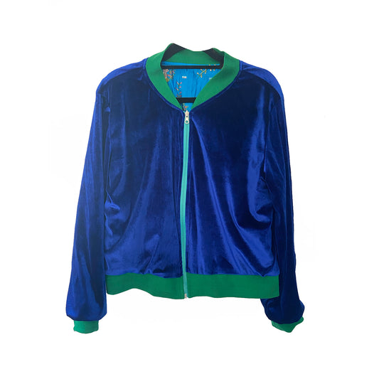 Blue velvet jacket with green trim on a white background