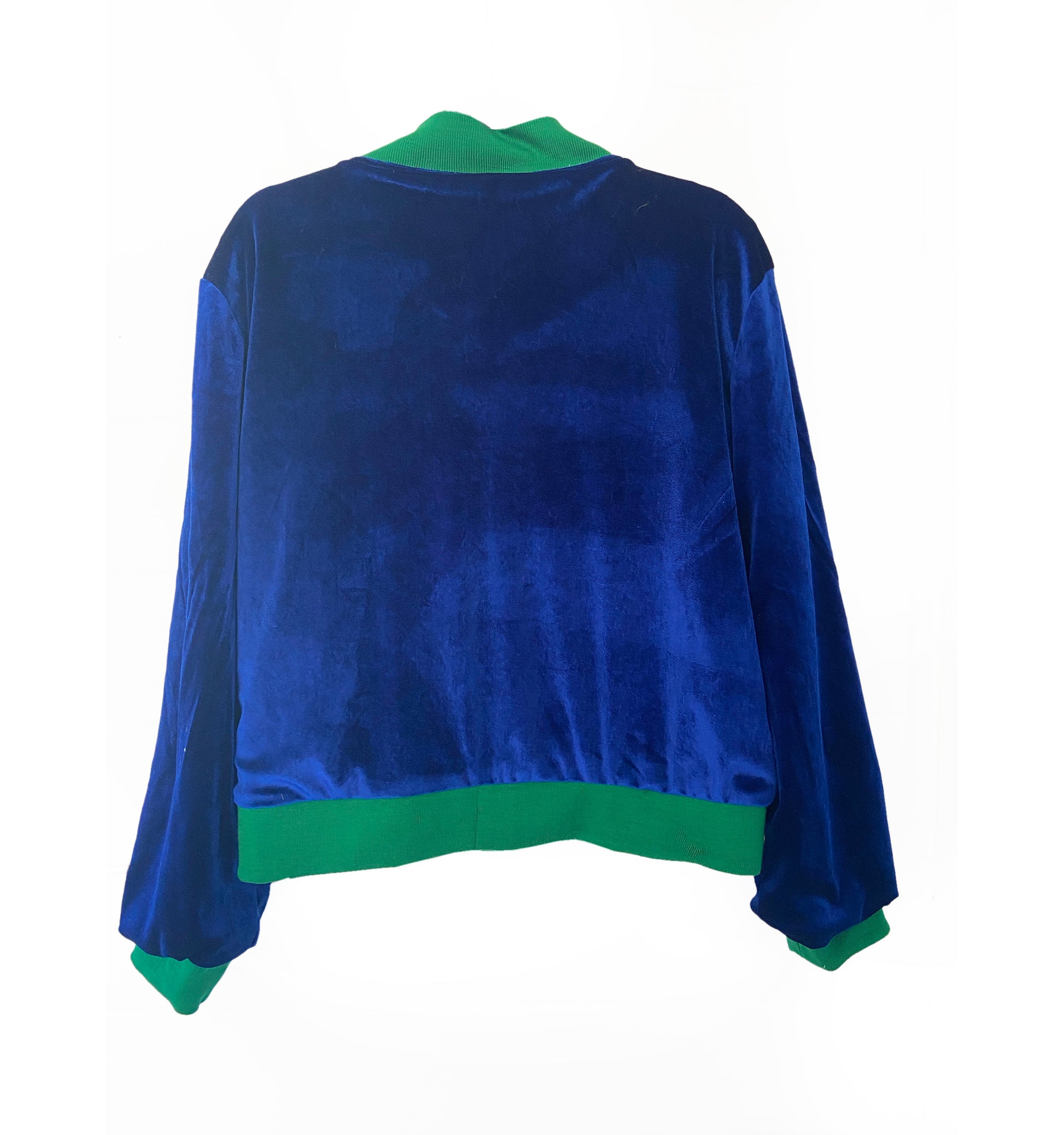Blue velvet jacket with green trim on a white background