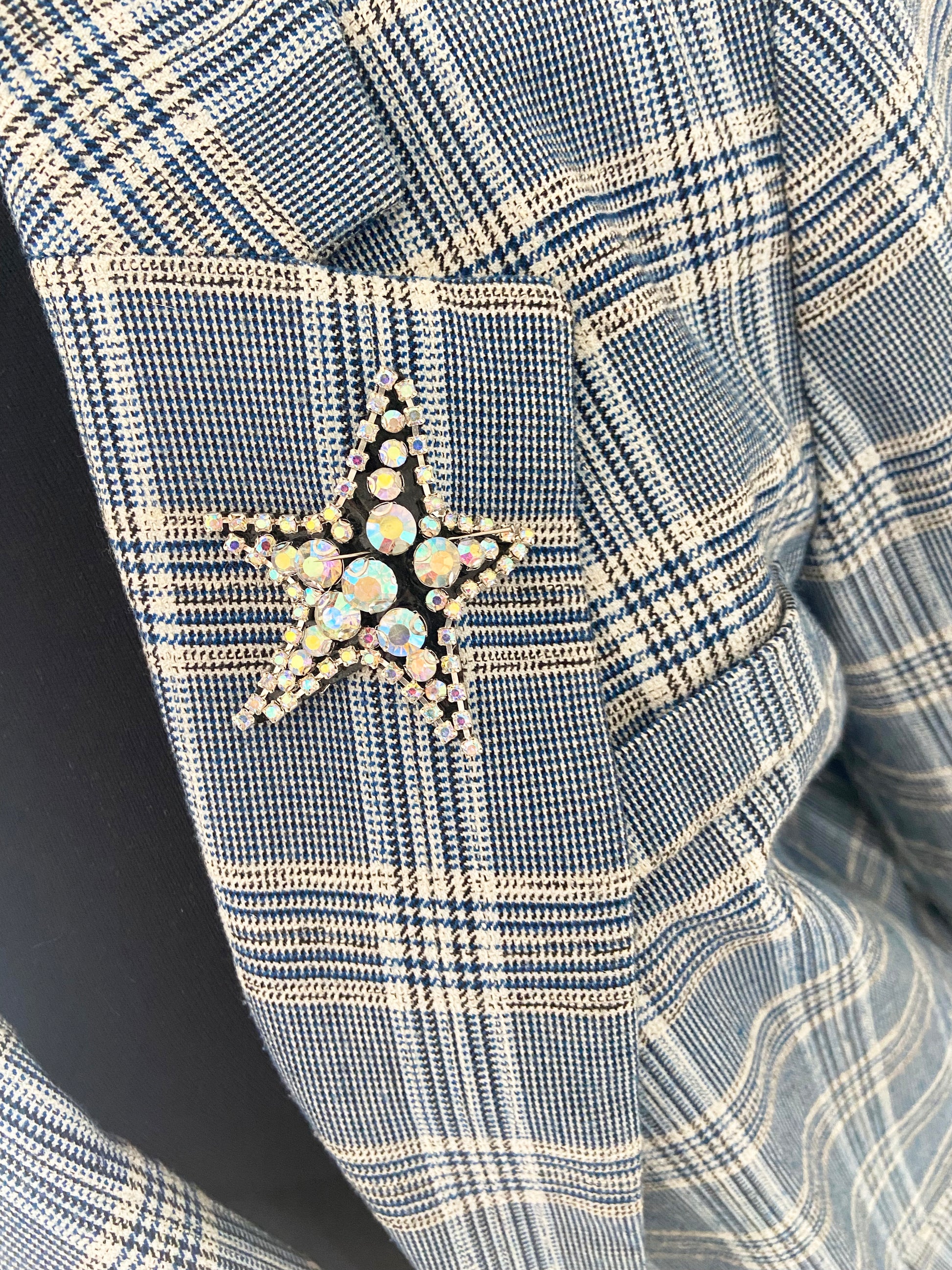 Close-up of a blue and white checkered fabric with a star-shaped brooch.