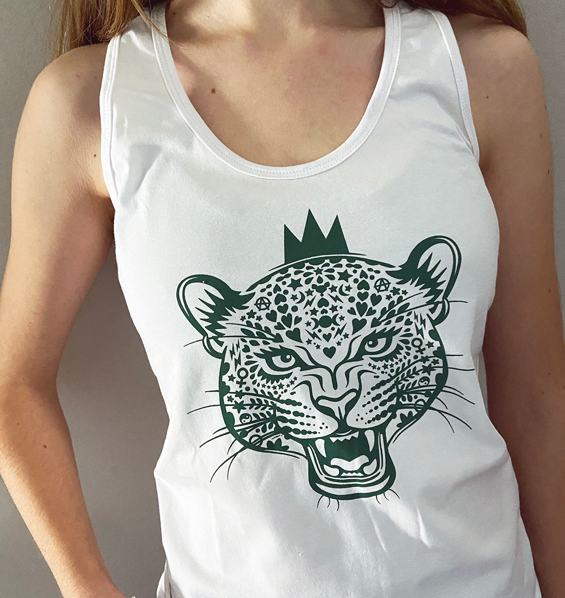 close up of a white vest with dark green leopard queen print