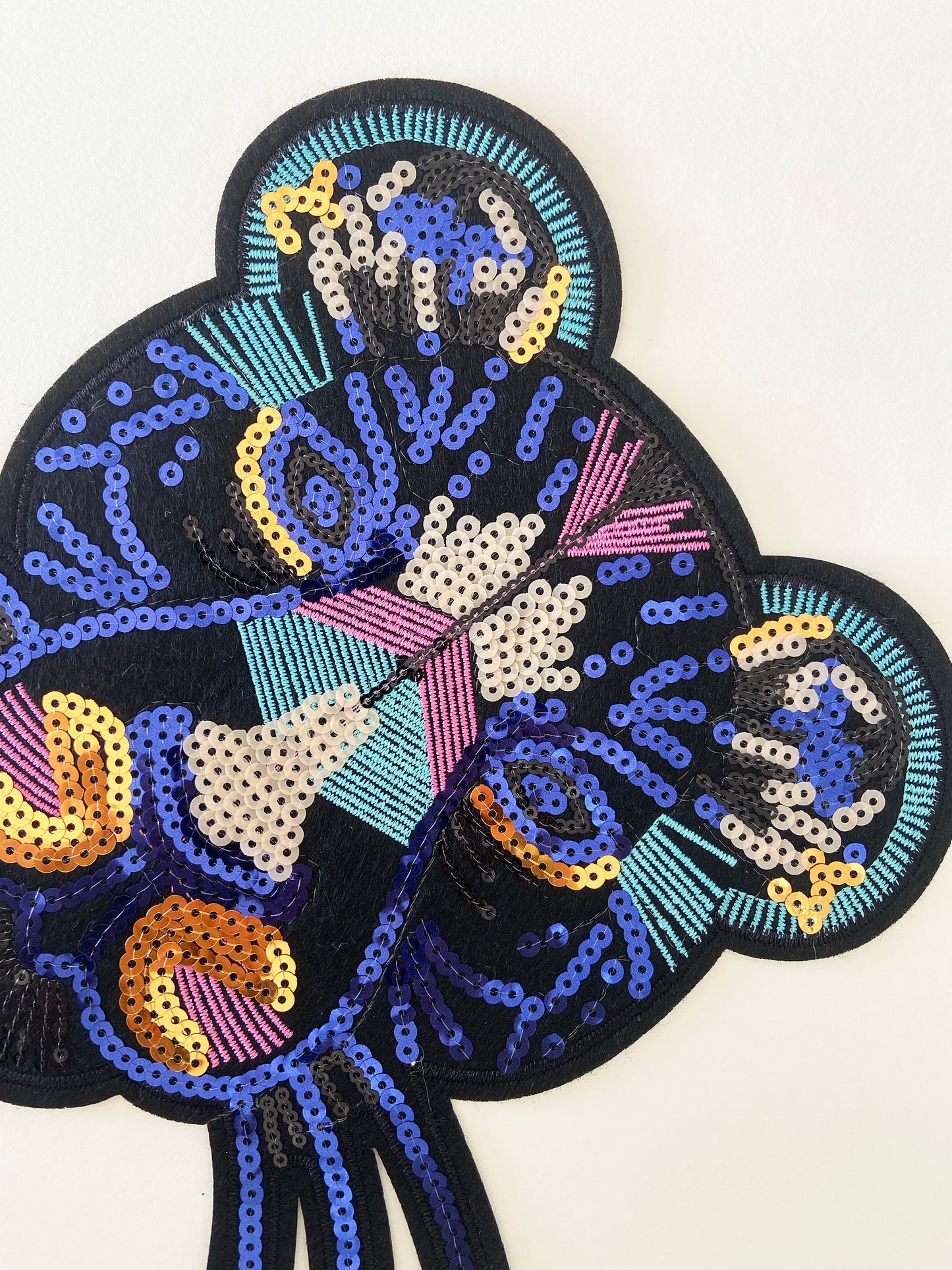 Decorative patch with colorful sequins on a white background