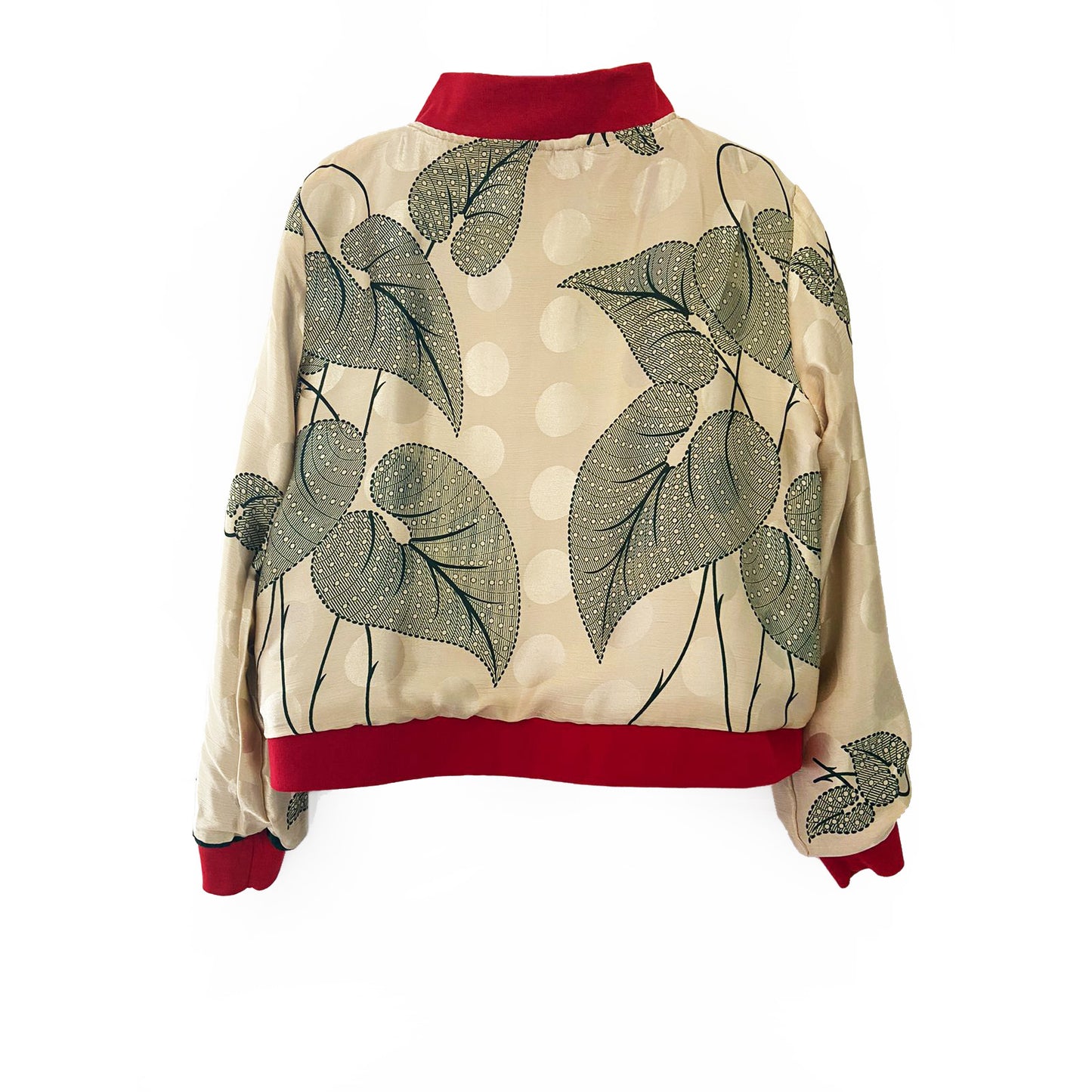 Cream silk bomber jacket with green leaf pattern and red trim on a white background