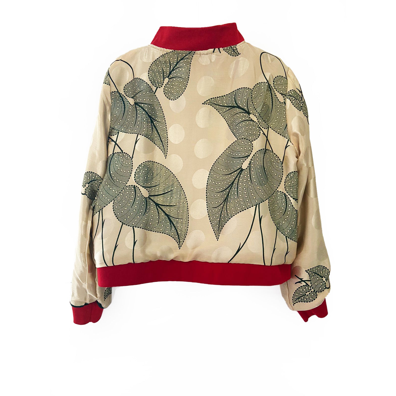 Cream silk bomber jacket with green leaf pattern and red trim on a white background