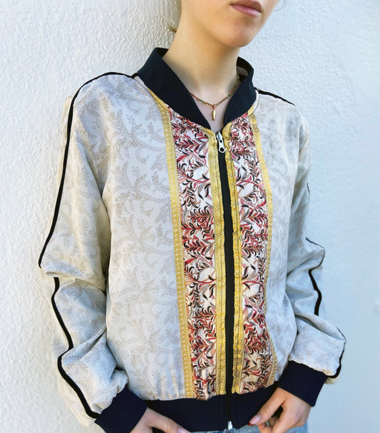Person wearing a patterned bomber jacket with a plain background