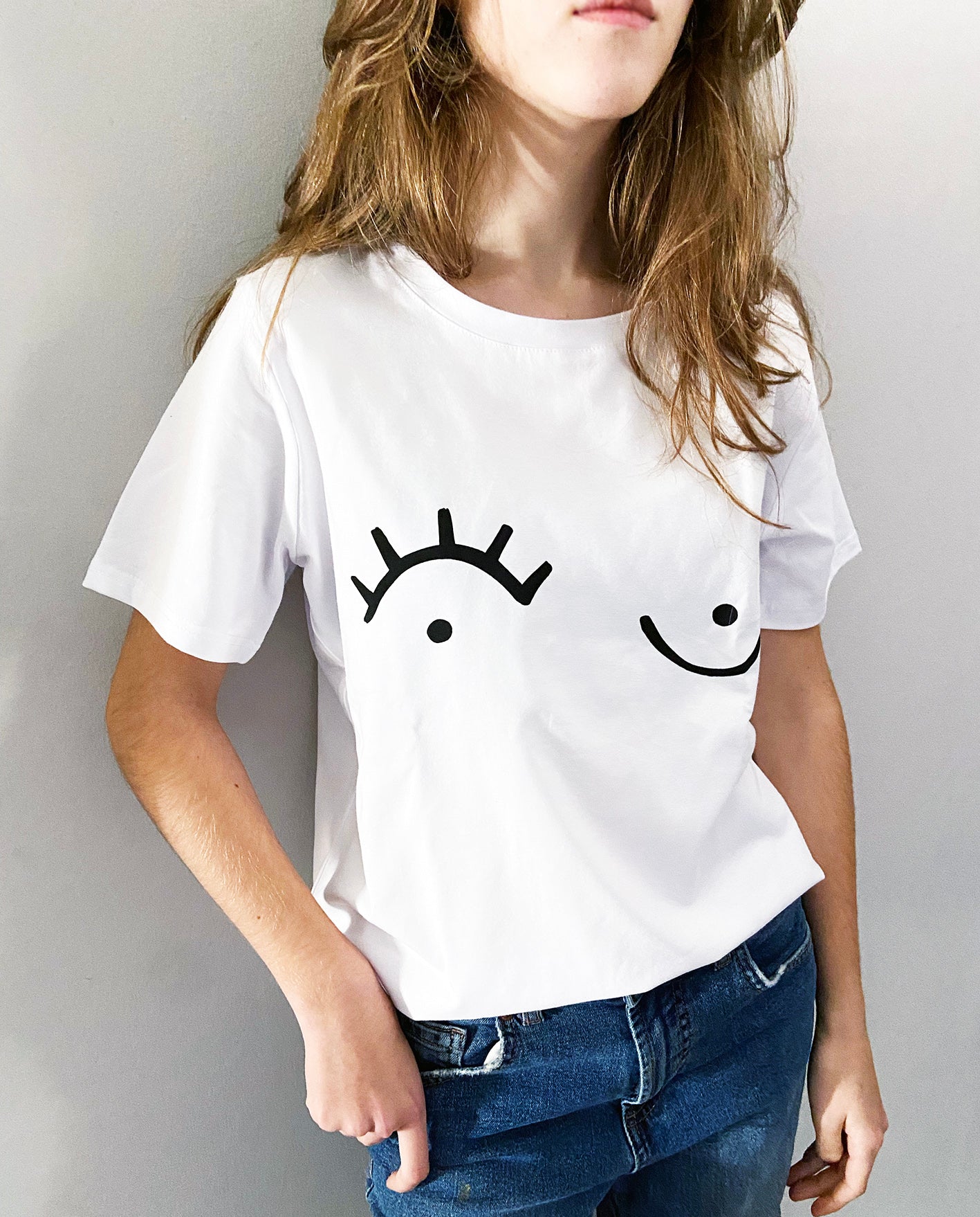 close up of young girl wearing a white t-shirt with black graphic print