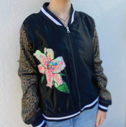 Black bomber jacket with a colorful floral design on a plain background