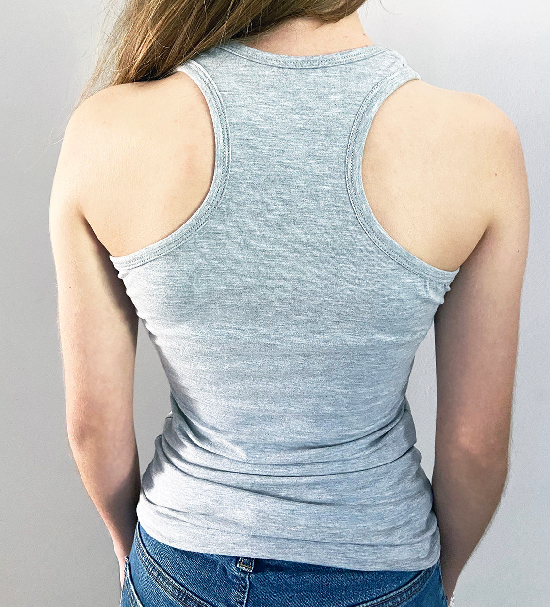 Close up of the back of a girl wearing a grey razor back vest