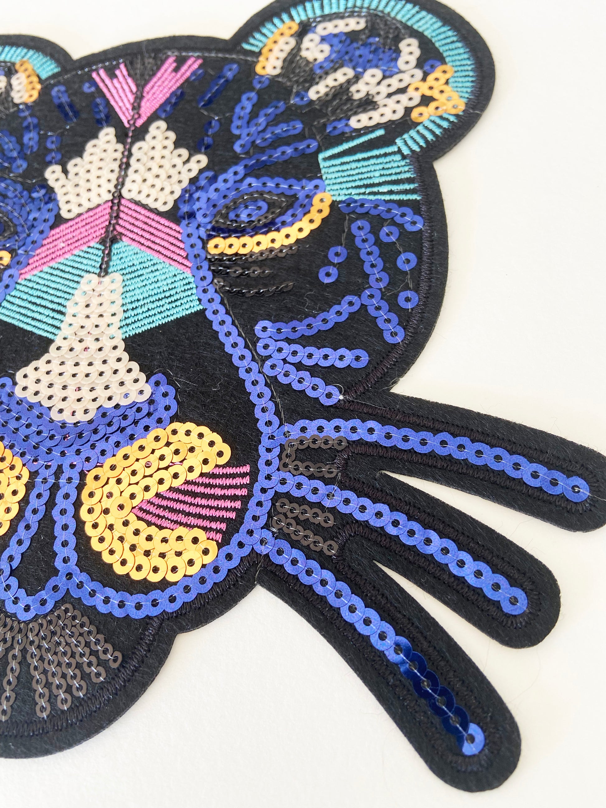 Colourful sequin patch with a leopard design on a white background