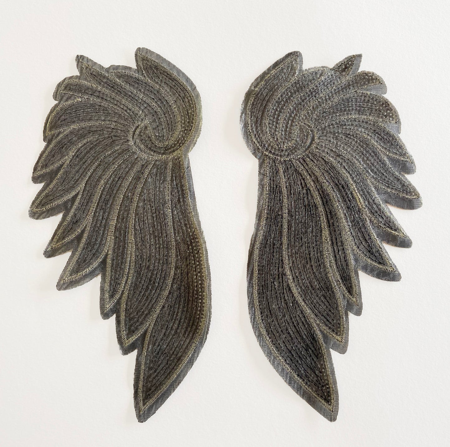 Back of a pair of wing-shaped patches on a white background