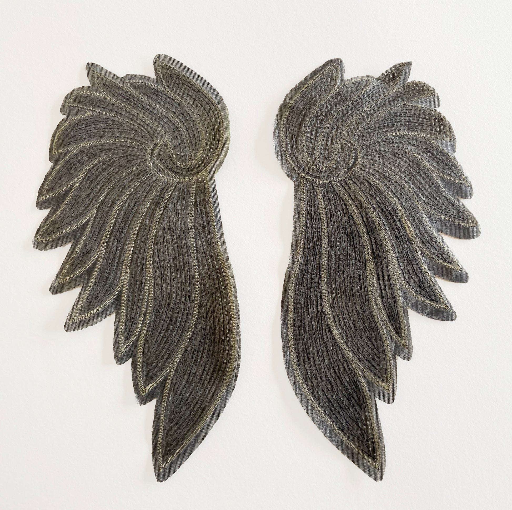 Back of a pair of wing-shaped patches on a white background