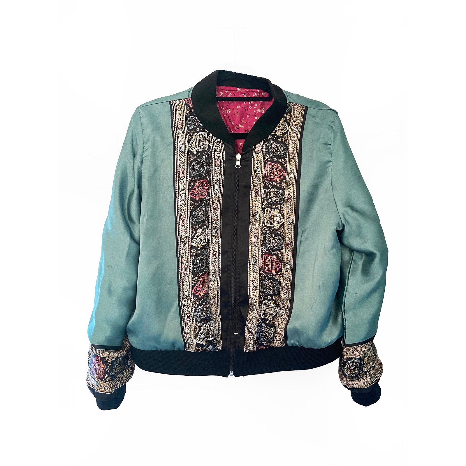 Teal blue silk jacket with intricate patterns on a white background
