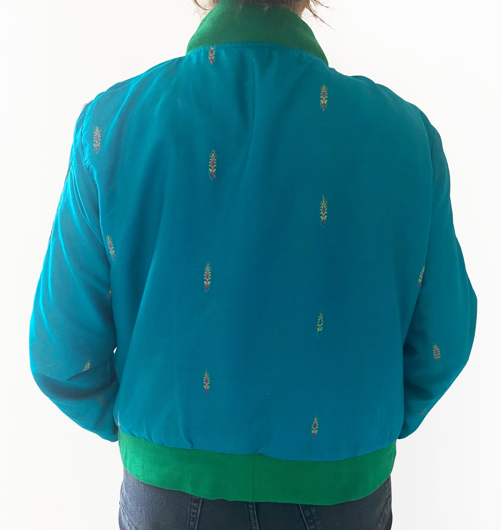 Blue jacket with green collar and cuffs on a white background